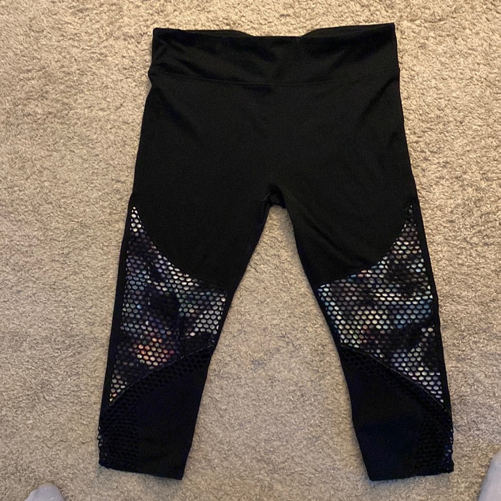 Black leggings with mesh pattern covering multi colored design. In a size large